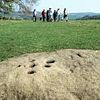 Walkers approaching boundary stone Eyam Derbyshire